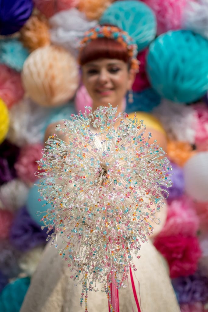 Stunning bespoke bouquet as an alternative to a wedding ring, photographed infront of a colourful background.