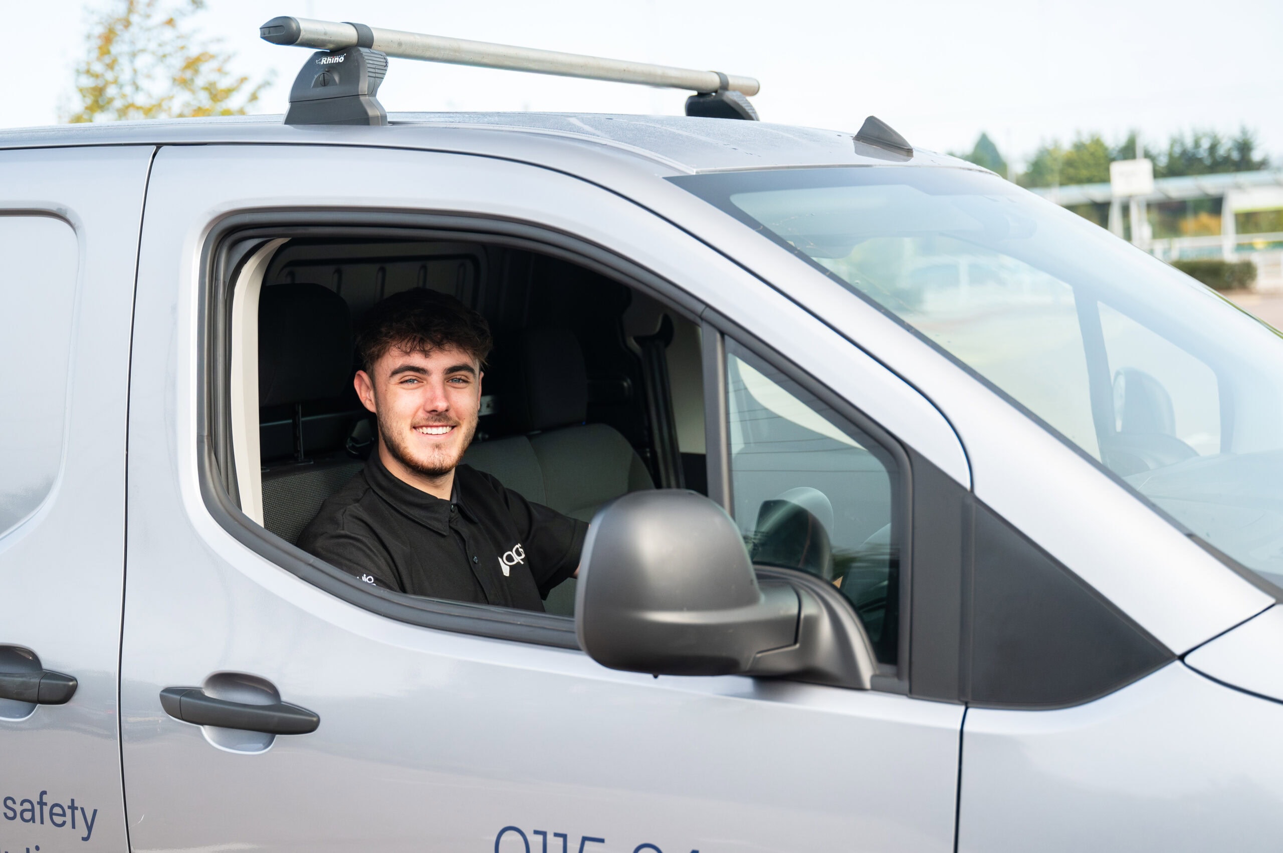 A smiling engineer at the wheel of his company van, commercial photography in Nottingham