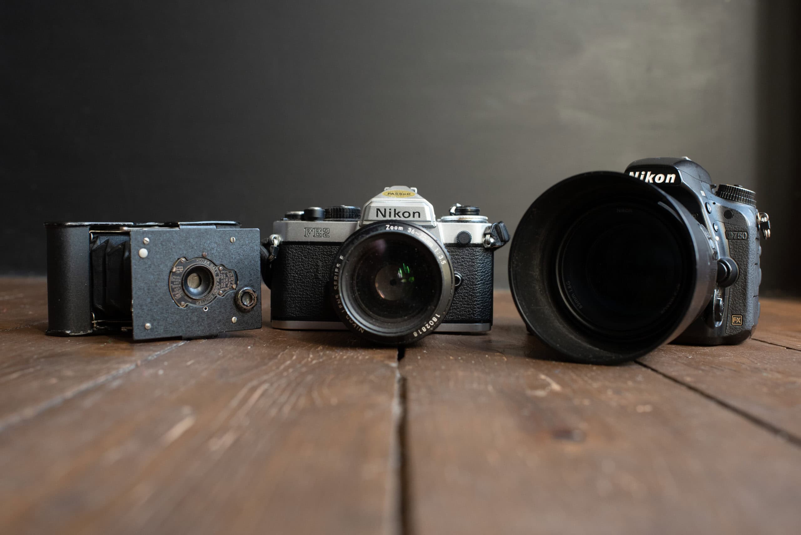 Three cameras on a wooden table