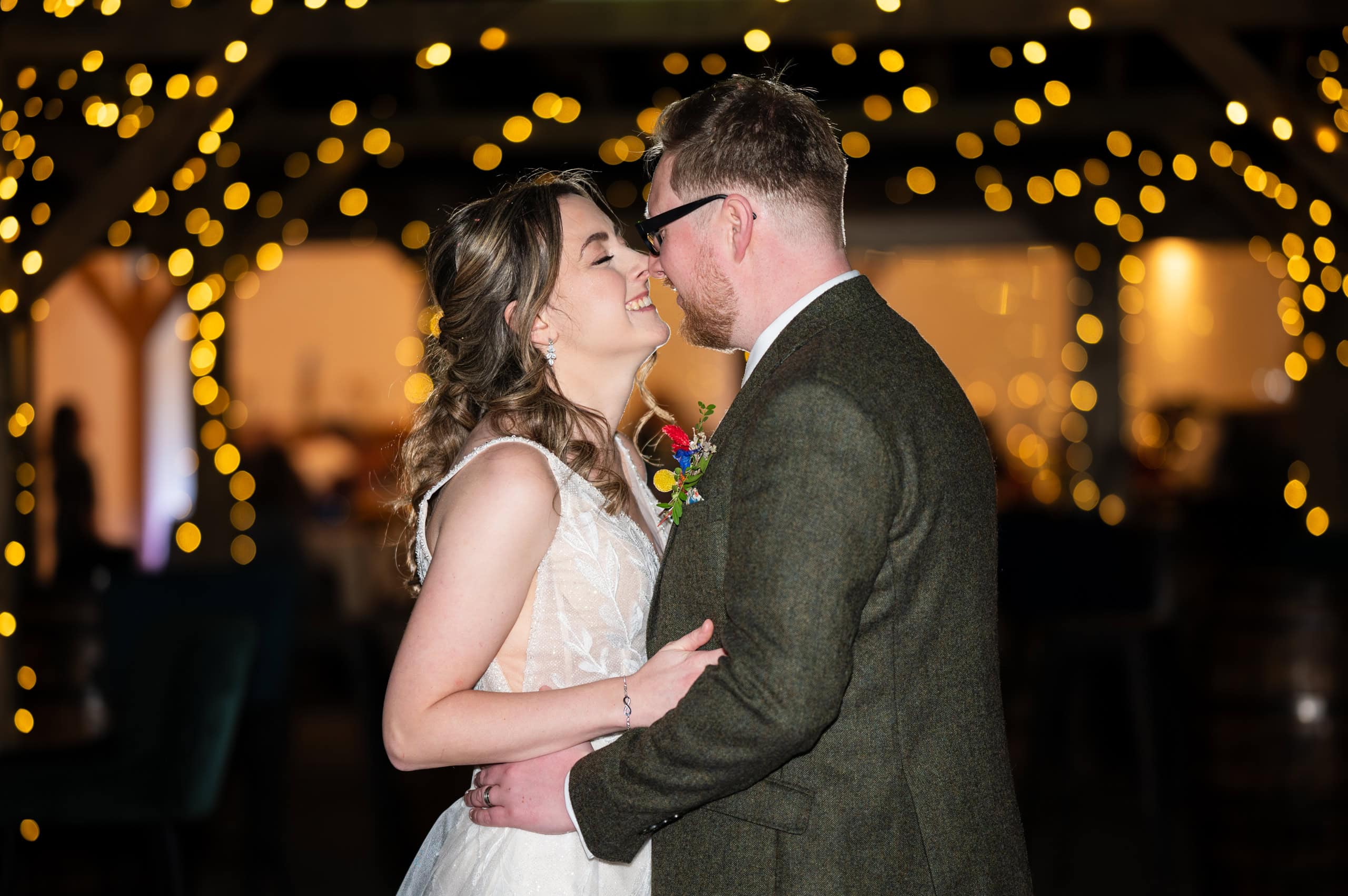 Bride and groom share their first dance under fairy lights at Coton House Farm
