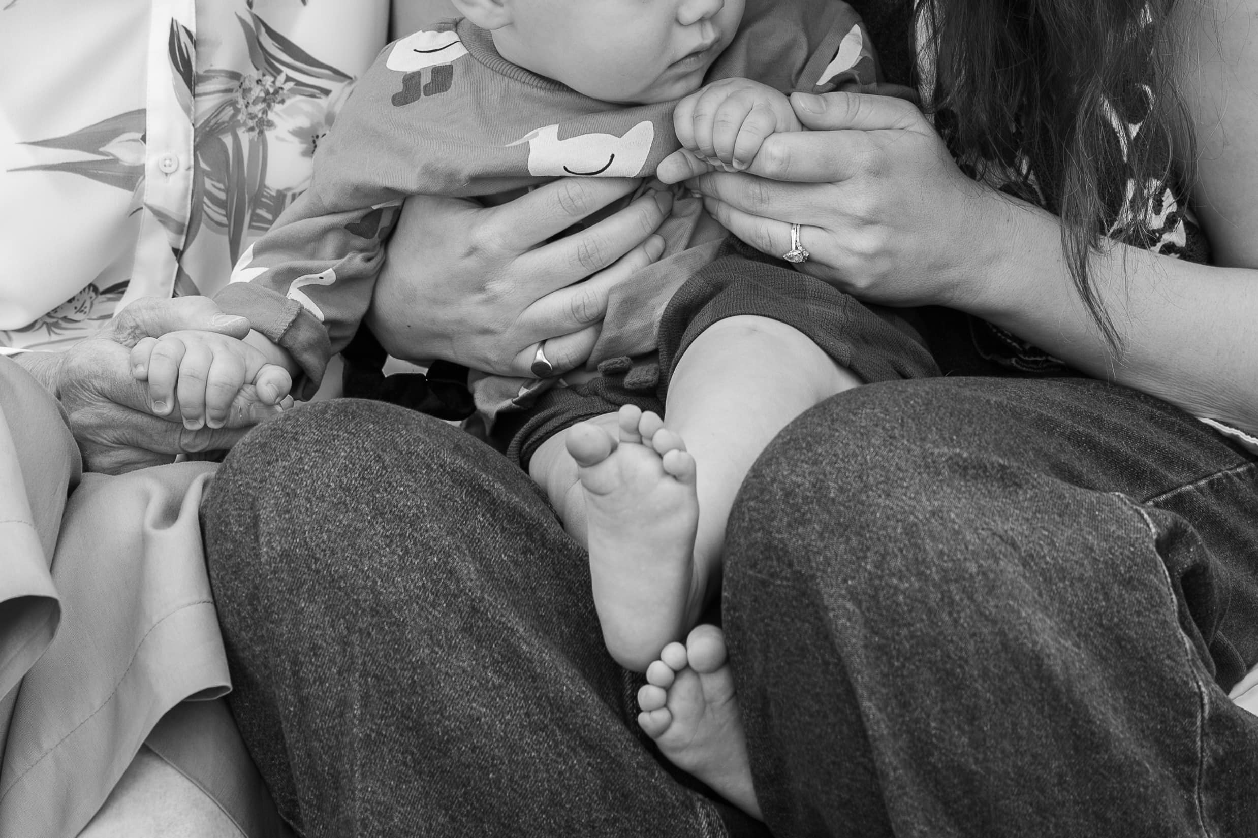 Black and white close-up of a baby held on a parent's lap