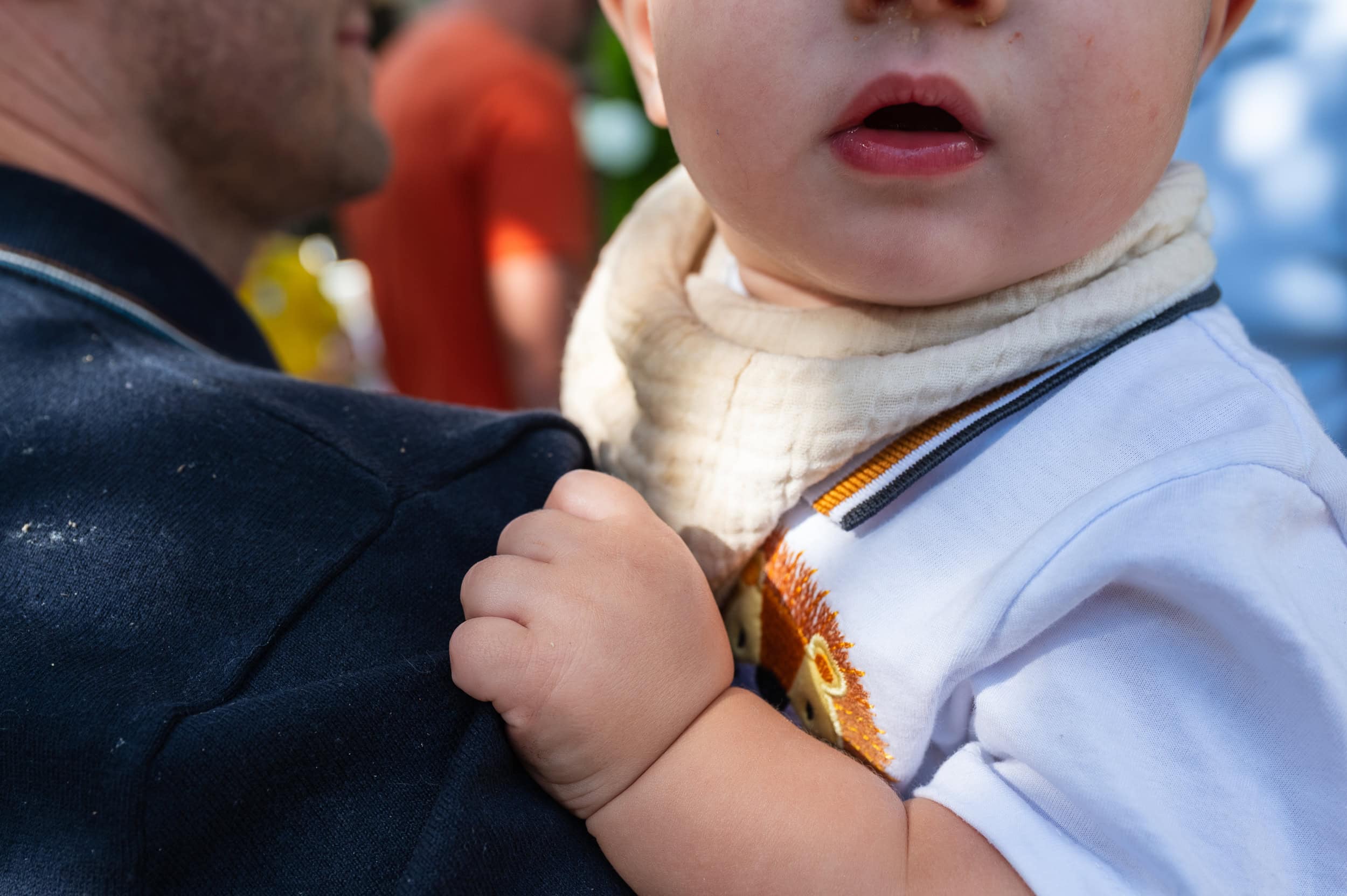 Close-up of a baby held in dad's arms