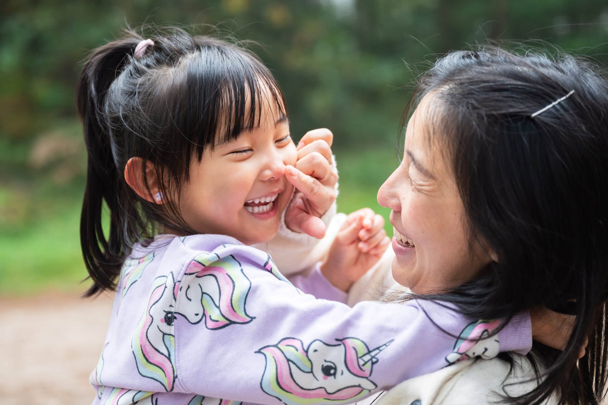 Mum and daughter laugh together outdoors, documentary family photography in Nottingham
