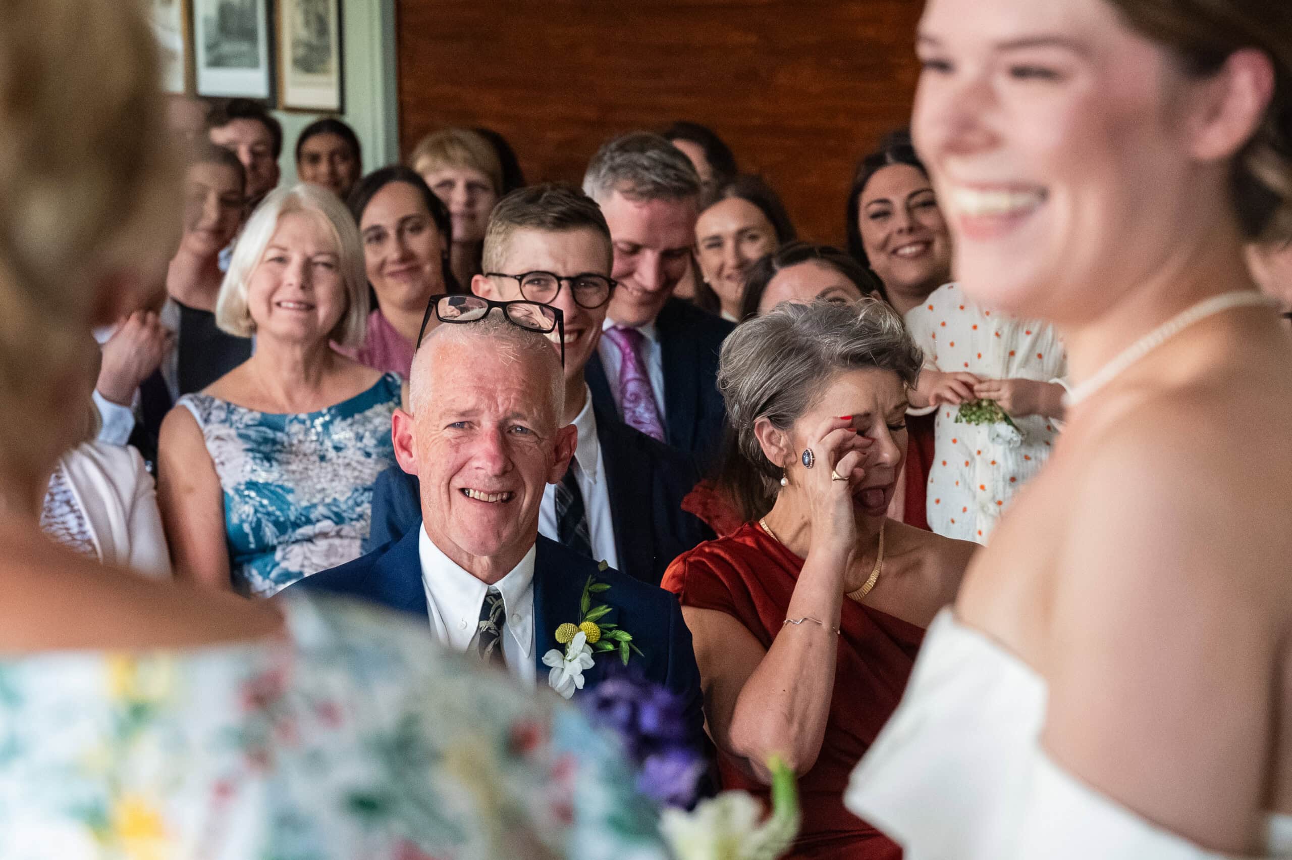 Wedding guests laughing and wiping away a tear during the speeches at London Rowing Club