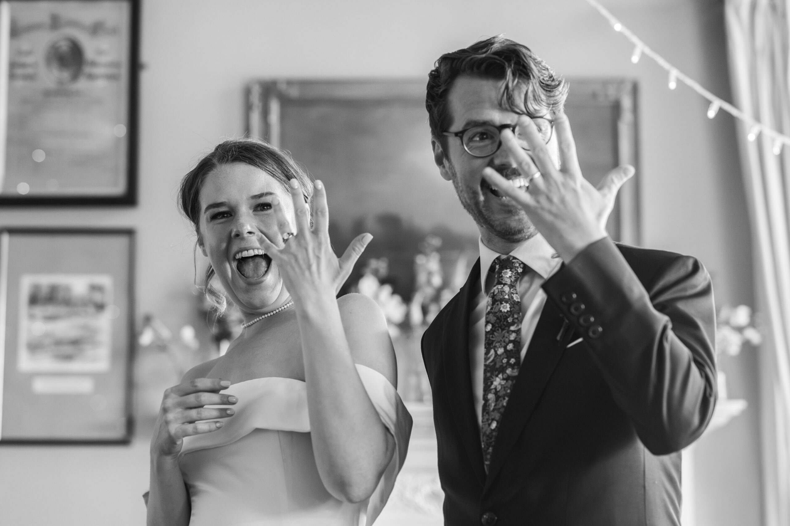Black and white photograph of wedding guests laughing during the speeches at London Rowing Club