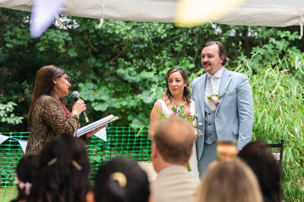 Jas from Infinite Celebrations leading Sabrina and Tim's garden wedding ceremony