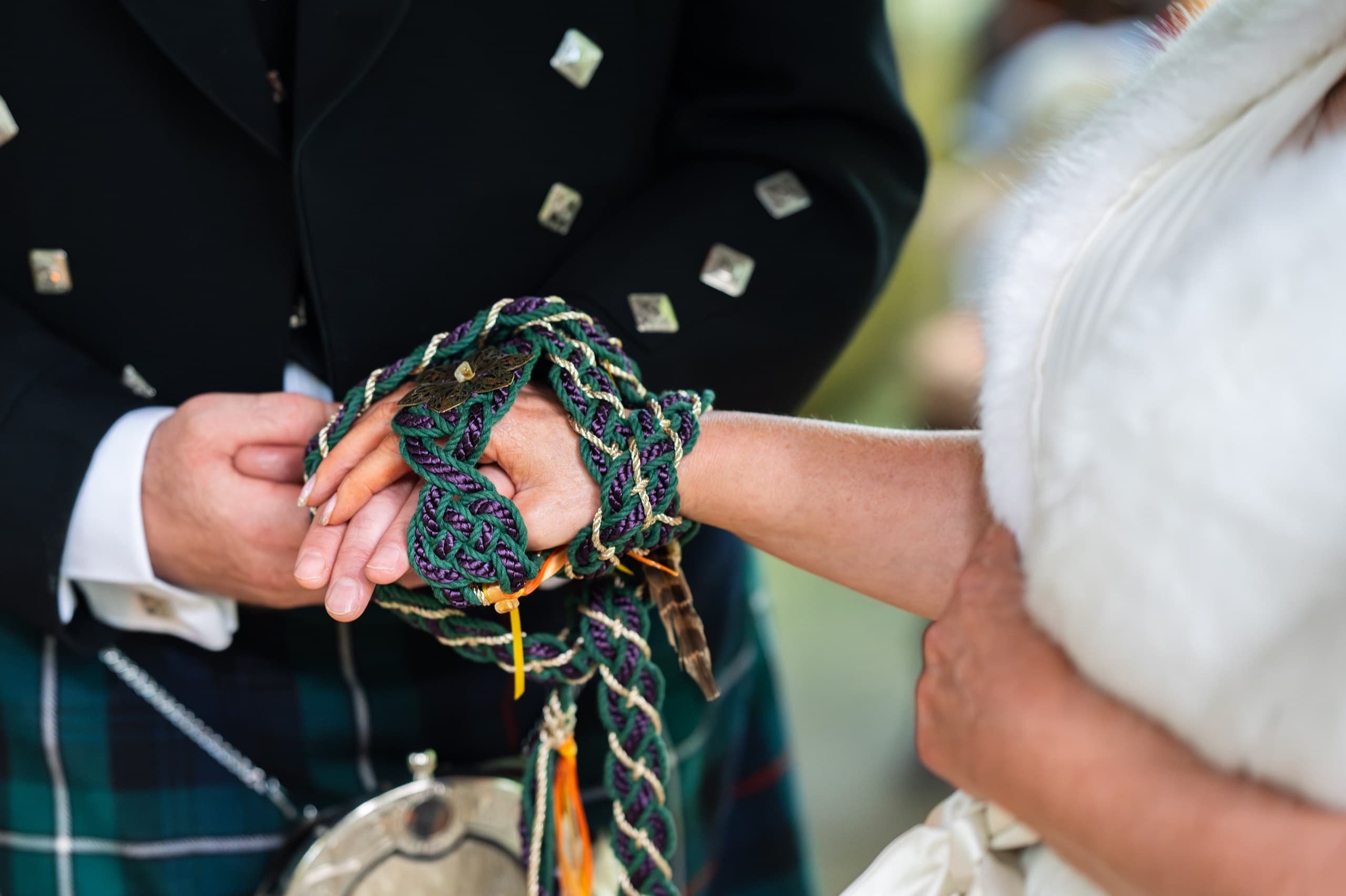 Lisa and George's hands tied with braided cords during their handfasting at Cedar Hollow
