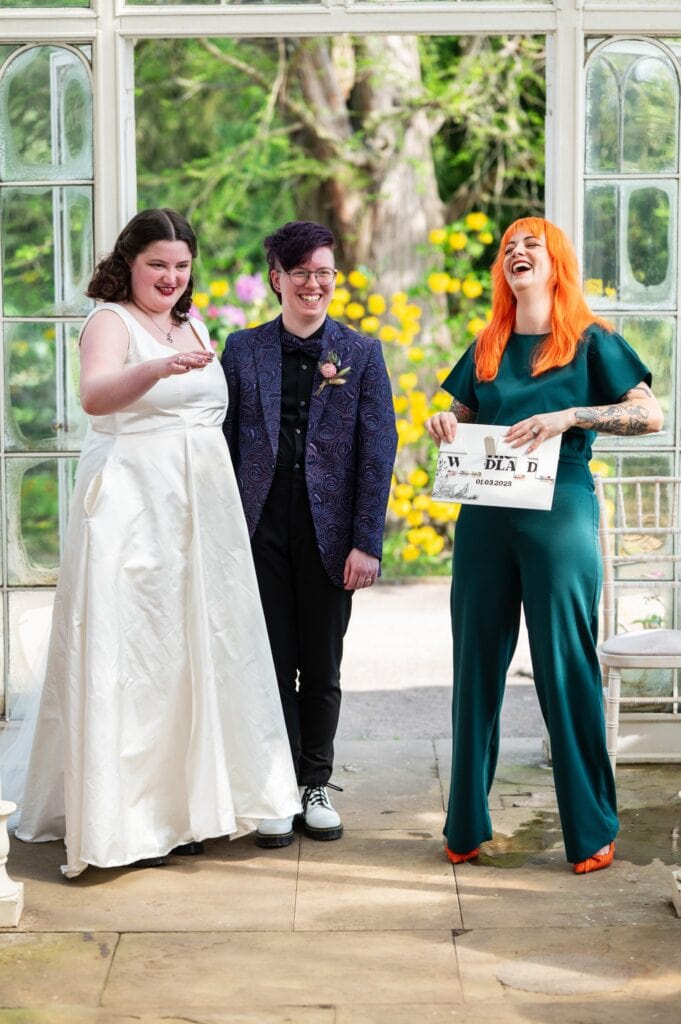Celebrant Louise laughing as she reveals Aleck and Joanna's new surname, Woodland, with a game of hangman at Wollaton Hall